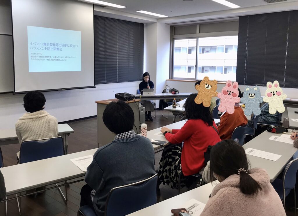 スクリーンに映る資料を見ながら研修に参加する参加者たちと説明する講師